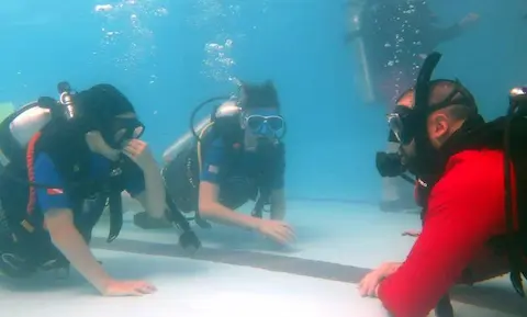 Divemaster dando un bautismo de buceo