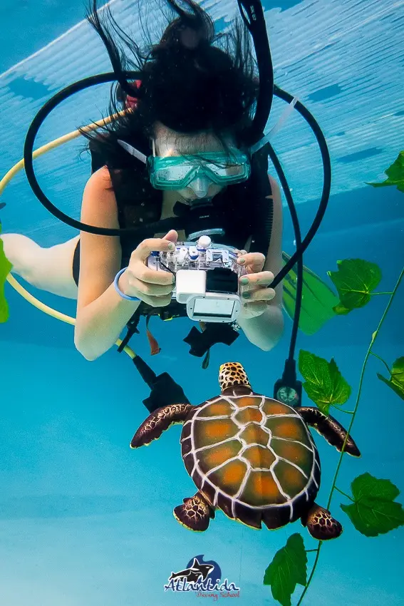 Alumno haciendo el curso de fotografía en pileta y fotografiando objetos.