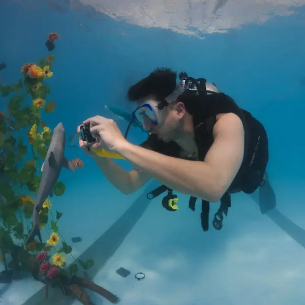 Alumno haciendo el curso de fotografía en pileta y fotografiando objetos
