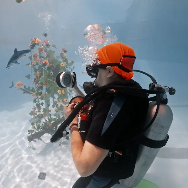 Alumno haciendo el curso de fotografía en pileta y fotografiando objetos