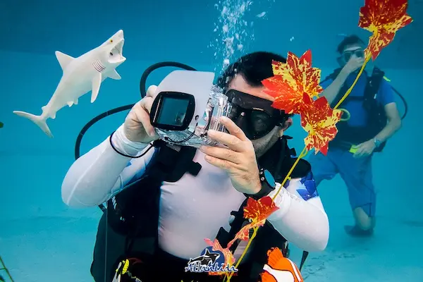 Alumno haciendo el curso de fotografía en pileta y fotografiando objetos