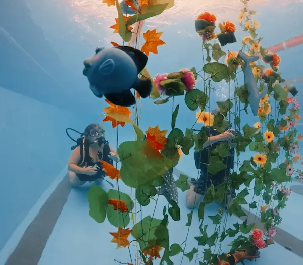 Alumno haciendo el curso de fotografía en pileta y fotografiando objetos